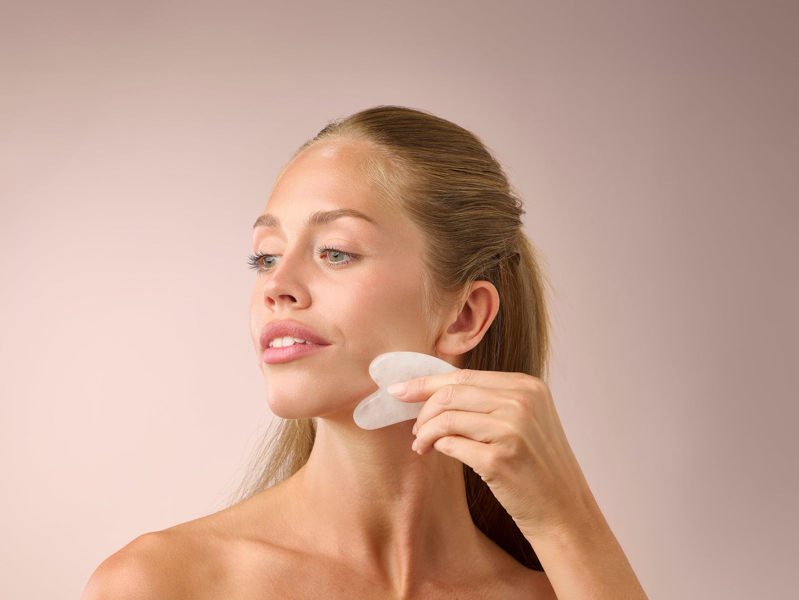 Donna durante una routine di cura della pelle con gua sha, immagine ufficiale Herbalife